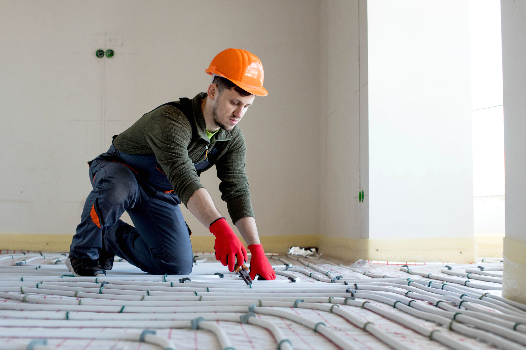 Worker is installing underfloor heating system. Warm floor heating system